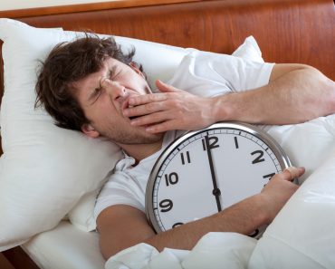 Man holding a big clock and waking up