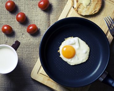 Frying egg in teflon cookware pan breakfast morning