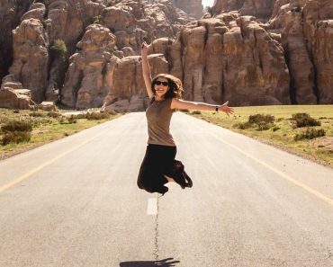 Woman jumping in midle of road