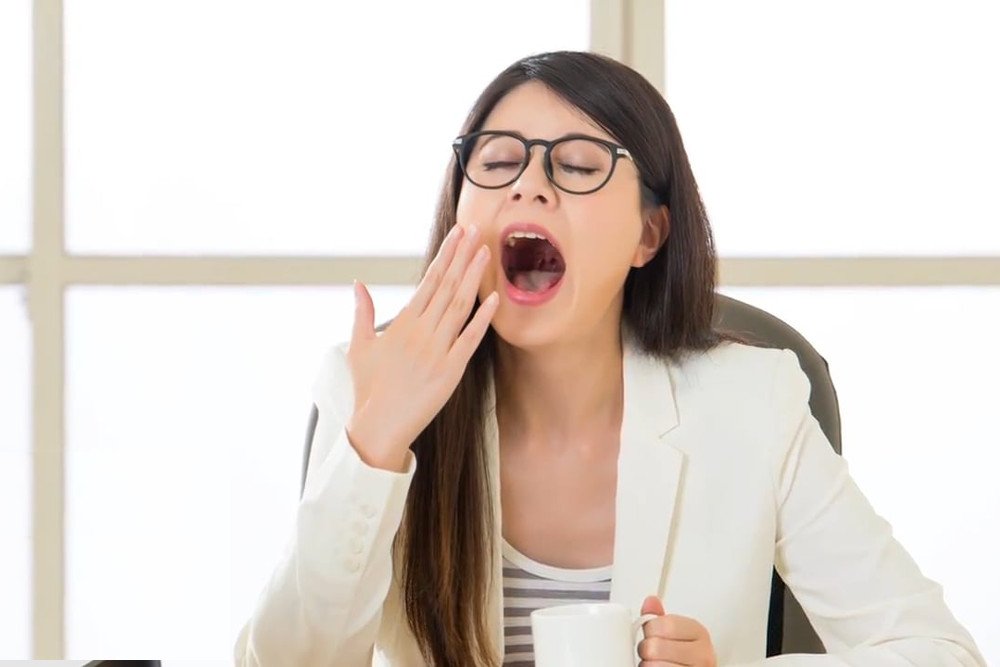 Yawning woman in office