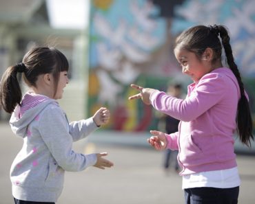 Two little girls playing Rock paper scissor playing children