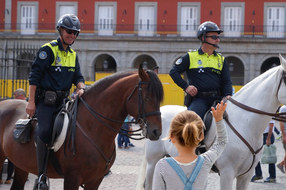 Mounted police officer smilling on little girl