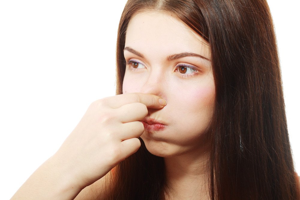Young Woman Holding her Nose smelling something stinking popping ear