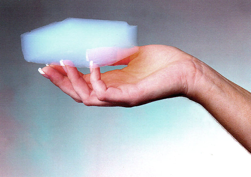 A piece of aerogel balanced on the nails of the hand, depicting its lightweight nature