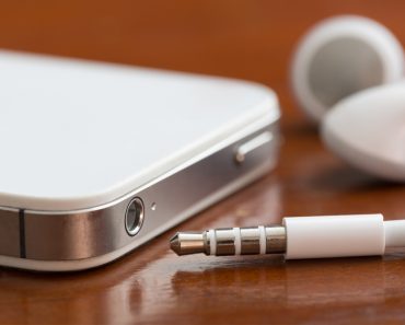 Close-up of a smartphone, earbuds, jack and port on a table with shallow depth of field - Image(David Smart)s