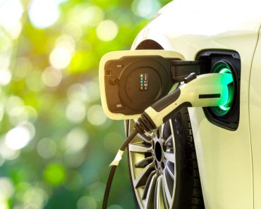 EV Car or Electric car at charging station with the power cable supply plugged in on blurred nature with soft light background. Eco-friendly alternative energy concept - Image(Smile Fight)s