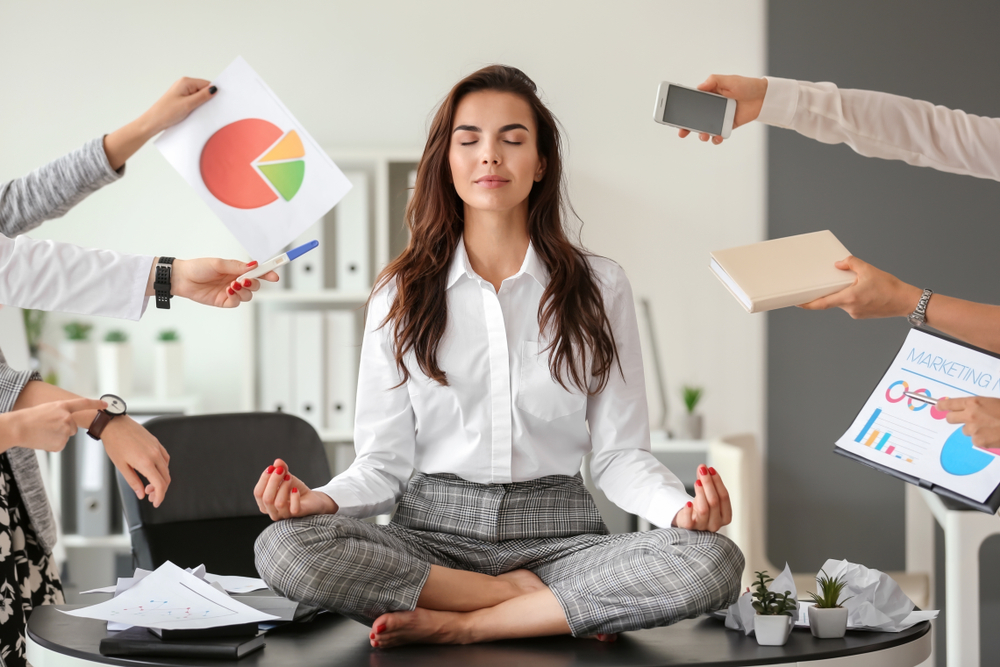 Businesswoman with a lot of work to do meditating in office - Image( Pixel-Shot)S