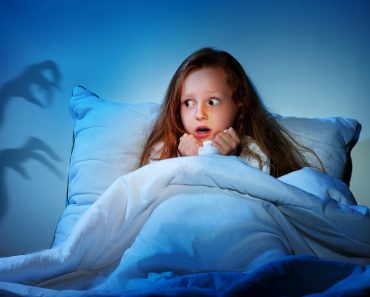 Sleepless girl in her bed having fears of night monsters - Image(Kasefoto)s
