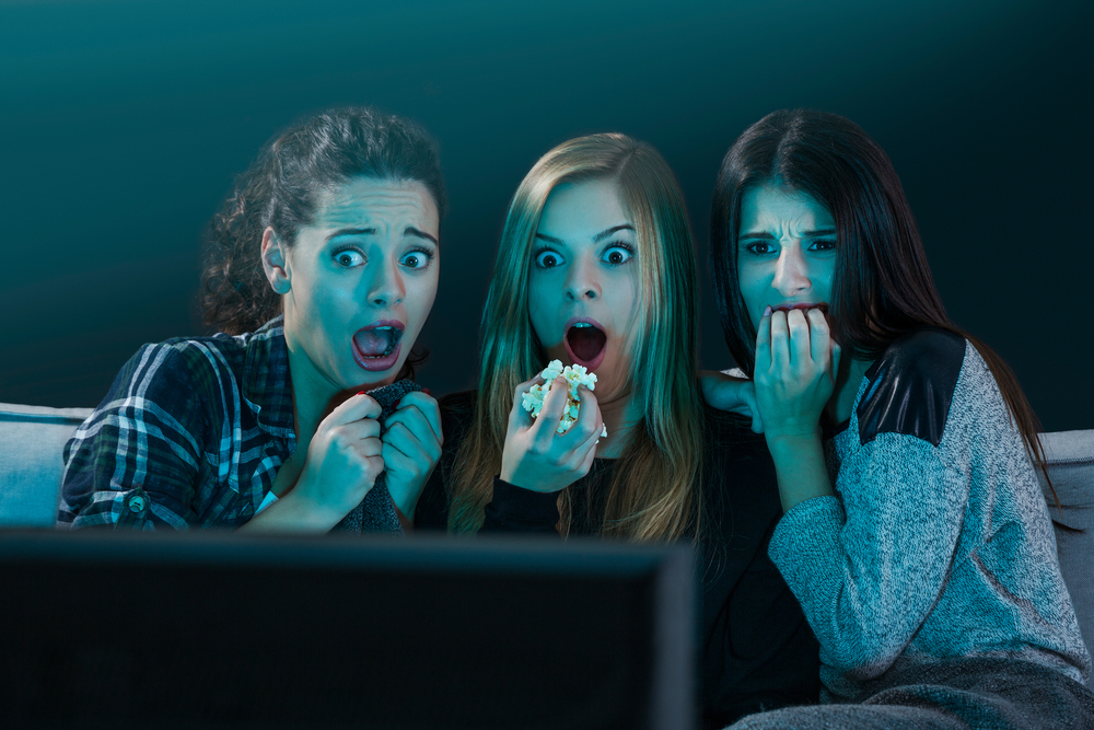 Teenage girls watching horror movie with popcorn - Image(iko)S