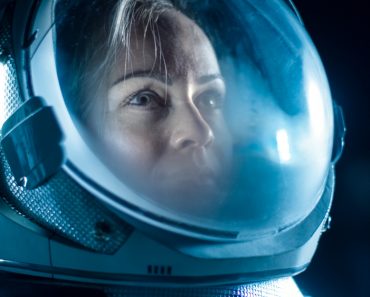 Female Astronaut Wearing Helmet in Space, Looking around in Wonder(Gorodenkoff)S