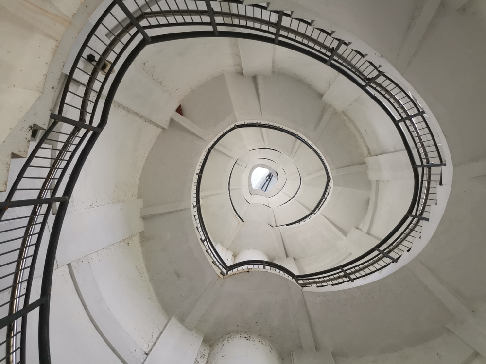 Spiral Staircase Going Up In A Lighthouse With Low Perspective and Reuleaux Triangle Shape - Looking Up At Circular Stairs - Image( Byron Van Gool)s