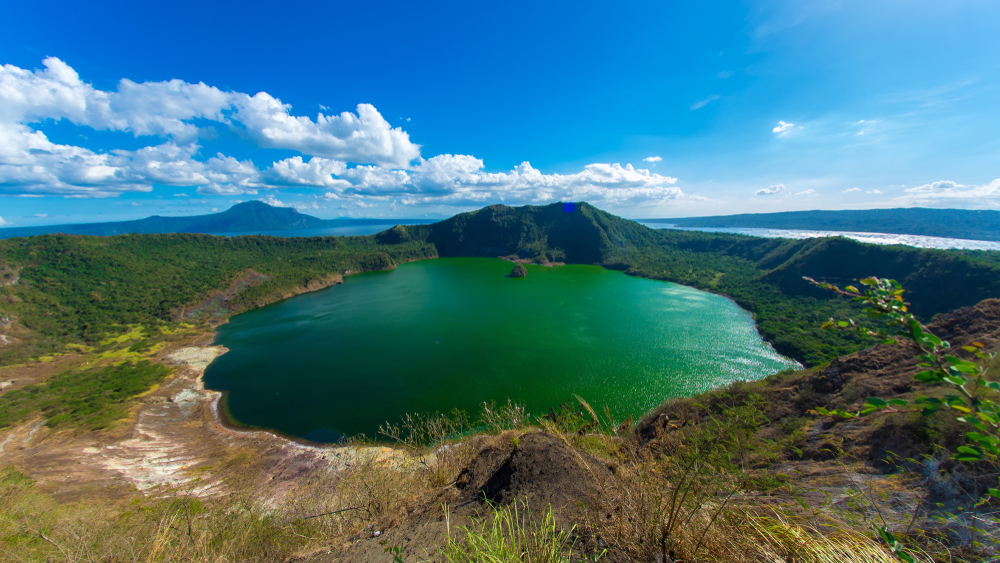 View of cones of Taal Volcano and the wind ruffled emerald green water in the Lake Taal on a sunny day in Tagaytay, Philippines. - Image(Spectral-Design)s