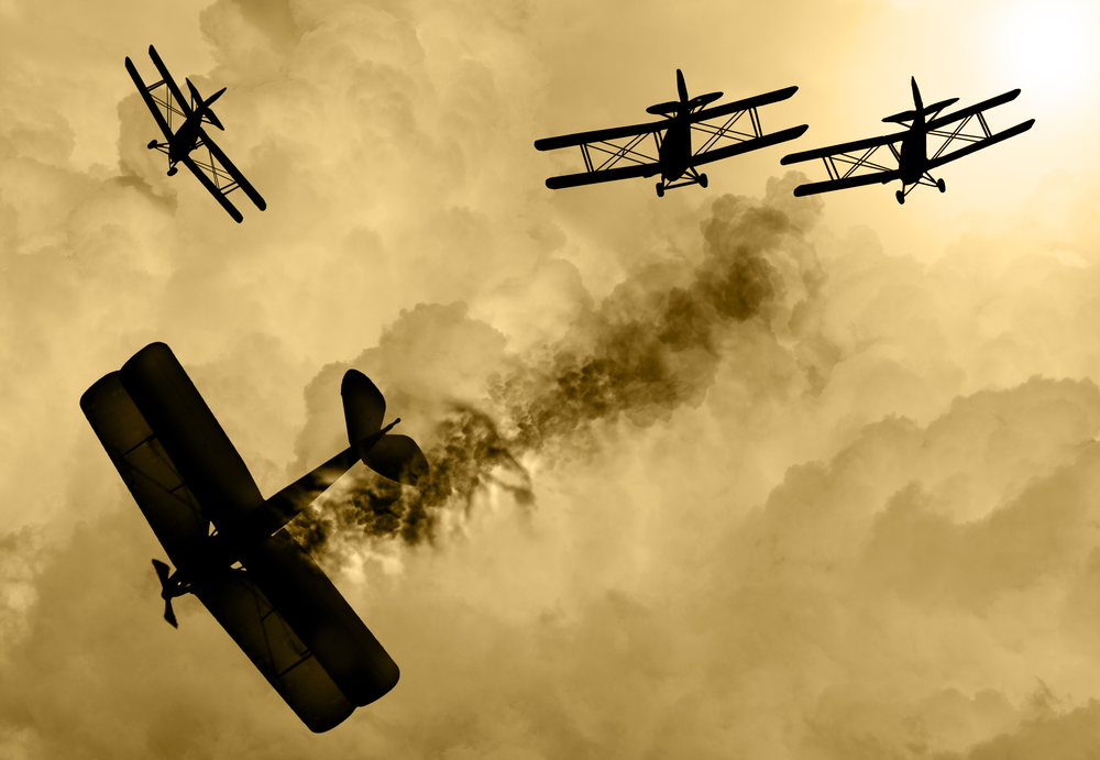 Vintage world war one biplanes and engaged in a dog fight in a cloudy sky. One had success in shooting down the enemy plane( Keith Tarrier)s