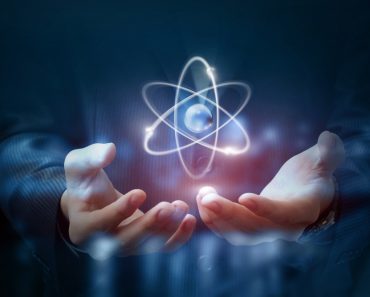 Hands shows the atom on a dark blurred background. - Image( Natali_ Mis)s