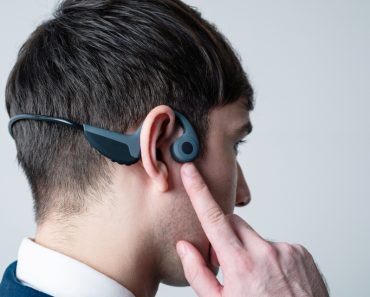 Young man wearing a bone conduction headphones(metamorworks)S