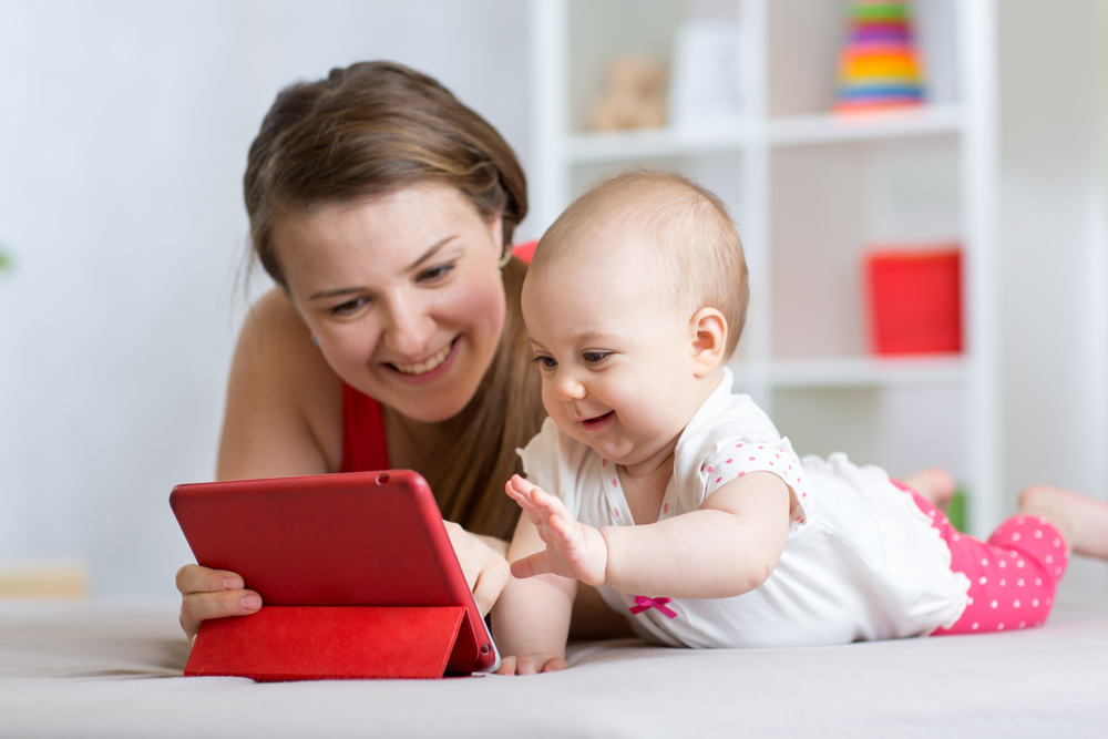 mother and baby with tablet on floor at home. Woman and child girl relaxing at tablet computer( Oksana Kuzmina)s