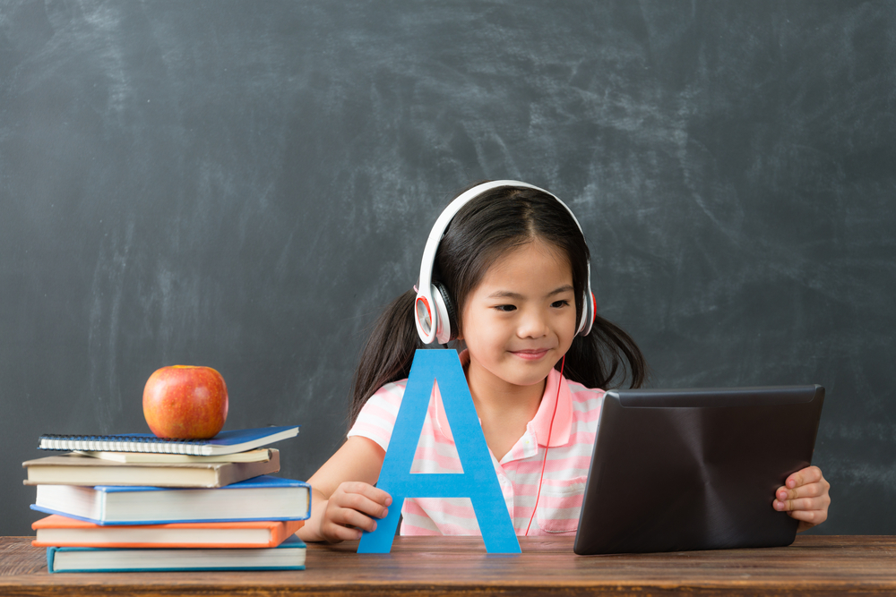 smiling young female kid children using digital tablet pad watching online e-learning video to studying english in chalkboard background. - Image(By PR Image Factory)s