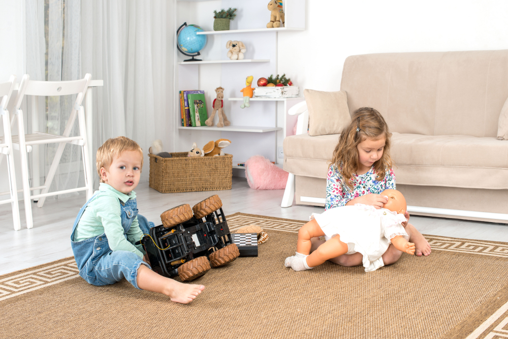 Little children, a boy and a girl, sit on the floor on a rug in the room at home and play(Rozochka)S