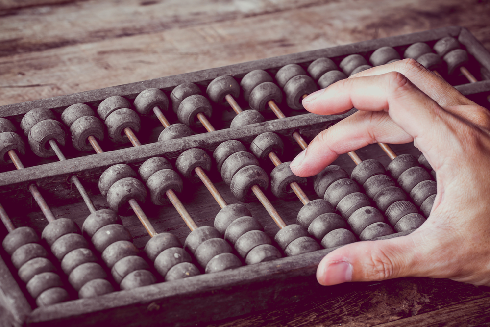Vintage tone of Man's hands accounting with old abacus and hold electronic calculator(Patty Chan)s