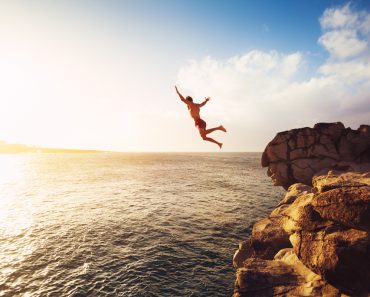 Cliff Jumping into the Ocean at Sunset(EpicStockMedia)S