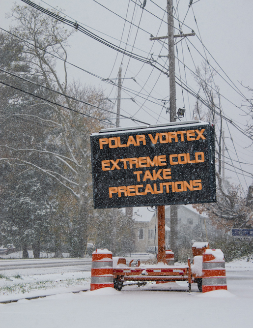 Electric road traffic mobile sign by the side of a snow covered road with snow falling warning of polar vortex(Alan Budman)s