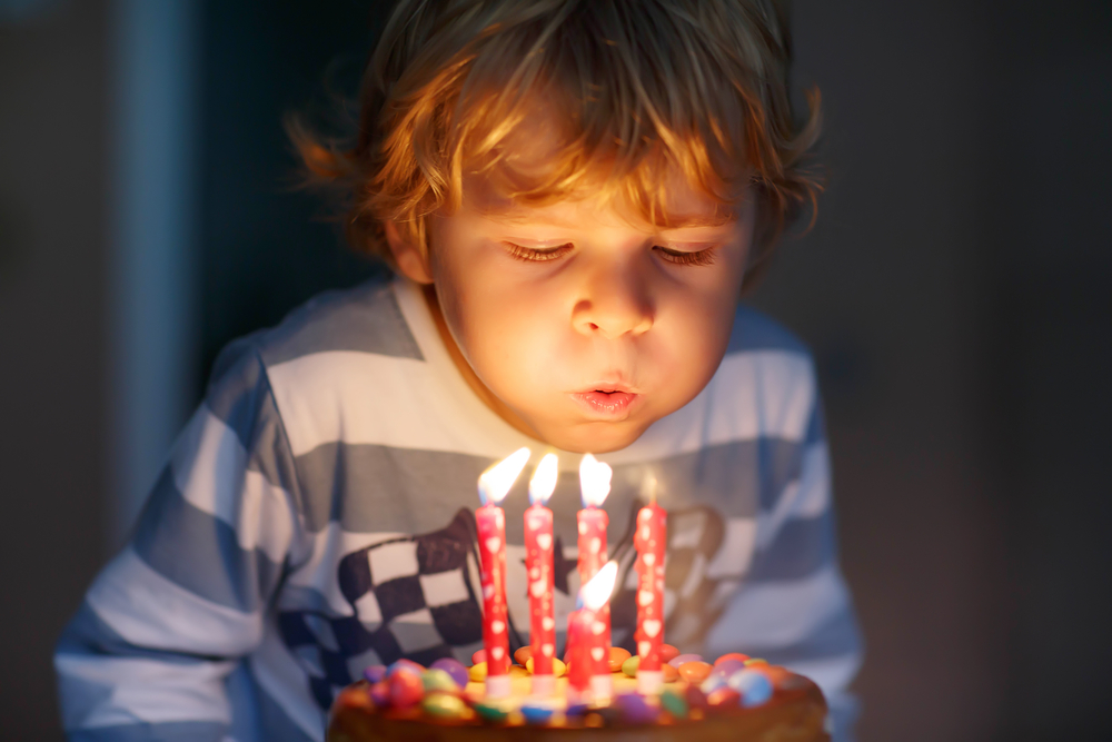 Adorable four year old kid celebrating his birthday and blowing candle(Romrodphoto)s
