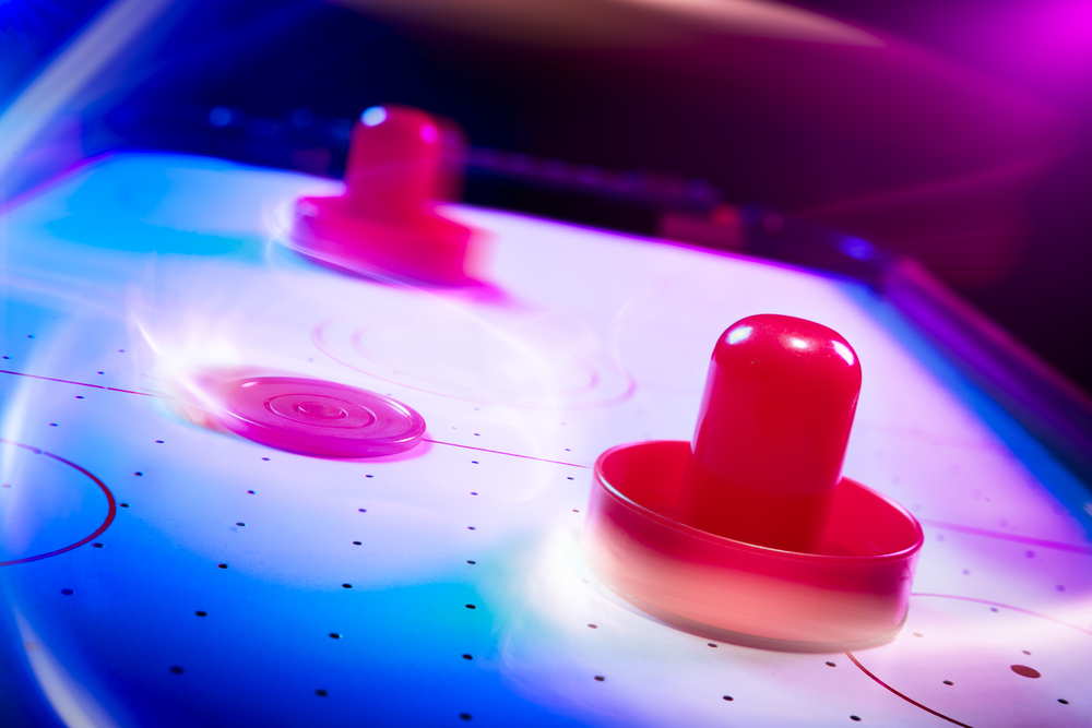 Air hockey table with dramatic lighting and motion trails(Fer Gregory)s