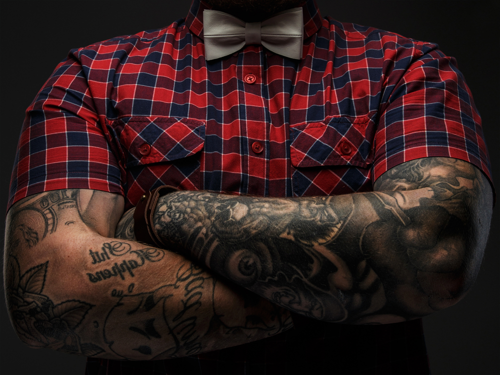 Portraite of brutal hipster with tattooes on his hand dressed in red shirt and bow tie(FXQuadro)S