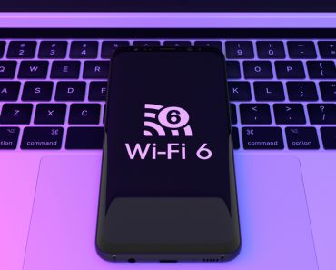 Wi,Fi,6,Logo,On,Smartphone,With,Laptop,Background.,Wi