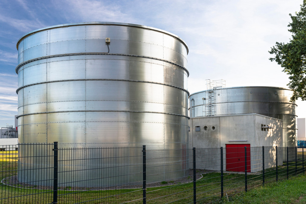 industrial-steel-silos-standing-on-the-factory-grounds-on-the-lawn-behind-the-fence-silos-silo_t20_NxKQNQ