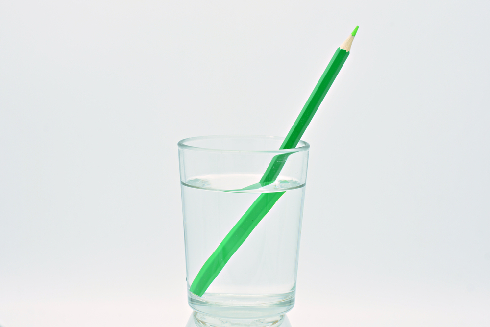 Green,Colored,Pencil,Inside,A,Glass,Of,Water,,Light,Refraction