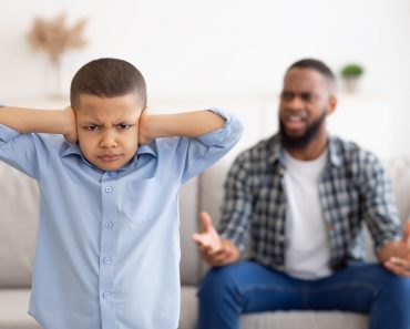 Black,Boy,Covering,Ears,While,Angry,Father,Shouting,At,Him