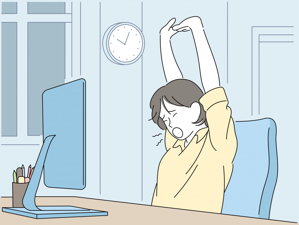 A woman is stretching while working overtime