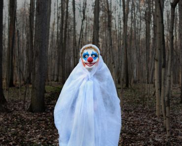 Evil,Clown,In,A,Mask,Standing,In,A,Dark,Forest