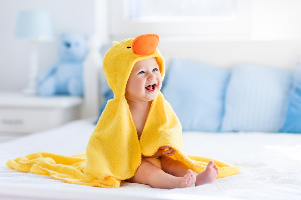 Happy,Laughing,Baby,Wearing,Yellow,Hooded,Duck,Towel,Sitting,On
